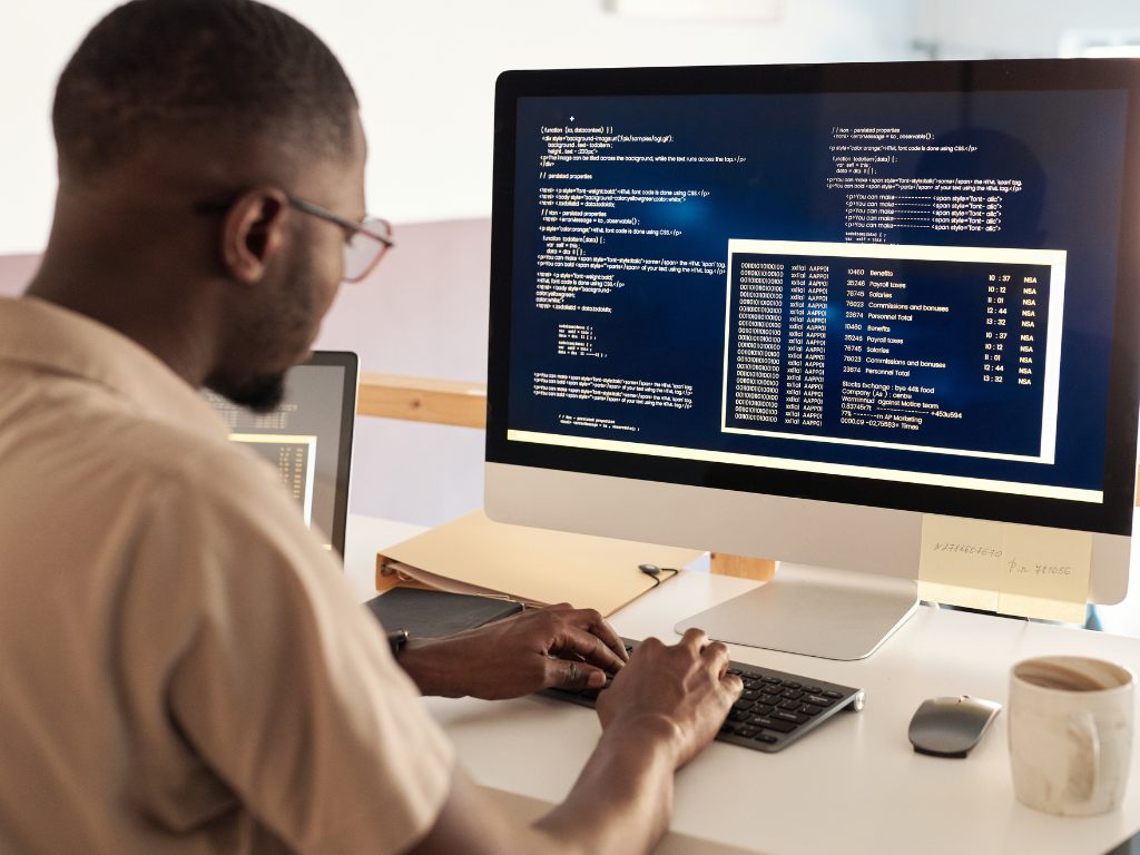 A man viewing internship tracking data on a computer screen.