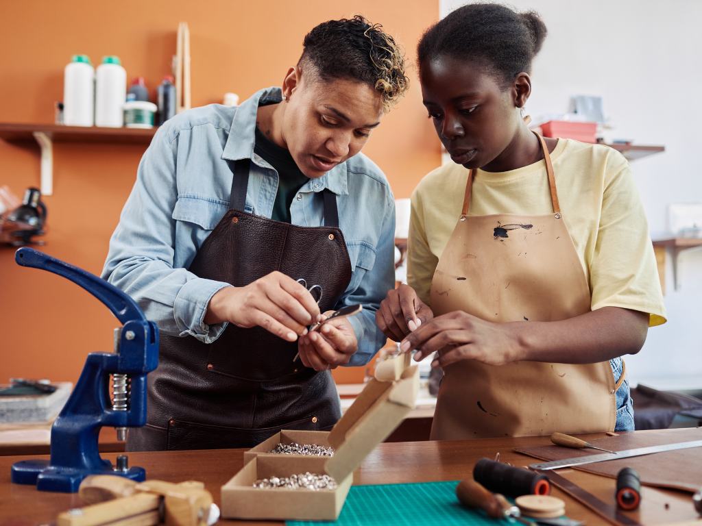 fresh-graduate-black-american-woman-5_opt An apprentice and her mentor engaged in hands-on learning in a workshop. Solid apprentice onboarding makes for better long-term relationships between apprentices and mentors.