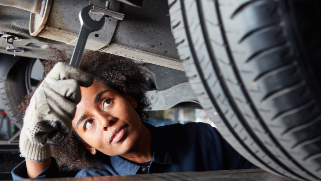 A young skilled trades apprentice at work on a vehicle.