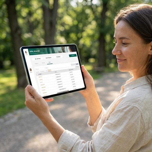 A woman figuring out how to track OJT hours for apprenticeships on a tablet device outdoors.