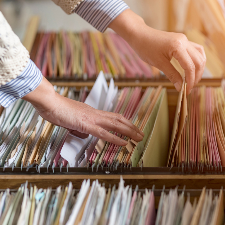 A woman's hands sorting through lots of paperwork.
