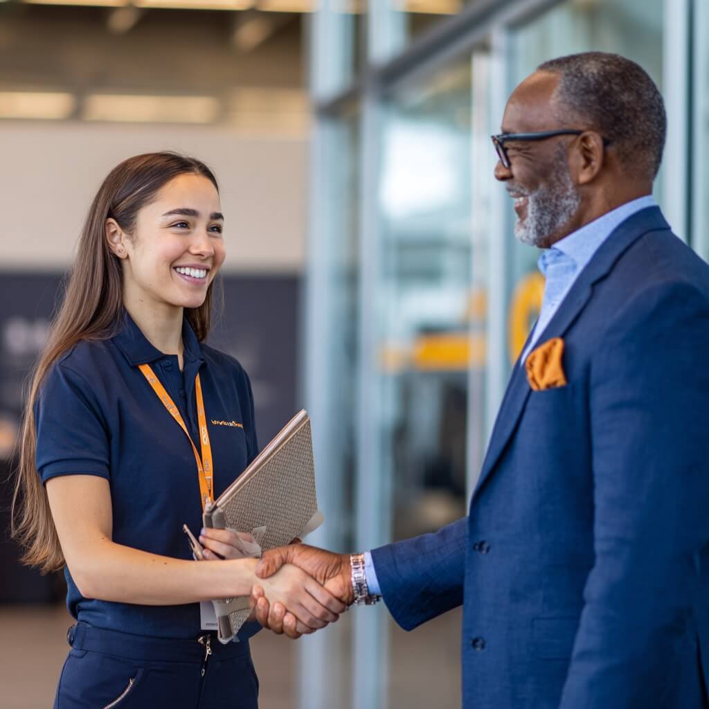 u2954471856_Editorial_realism_medium_shot_of_a_Hispanic_22yr A young apprentice shaking hands with a senior program sponsor.